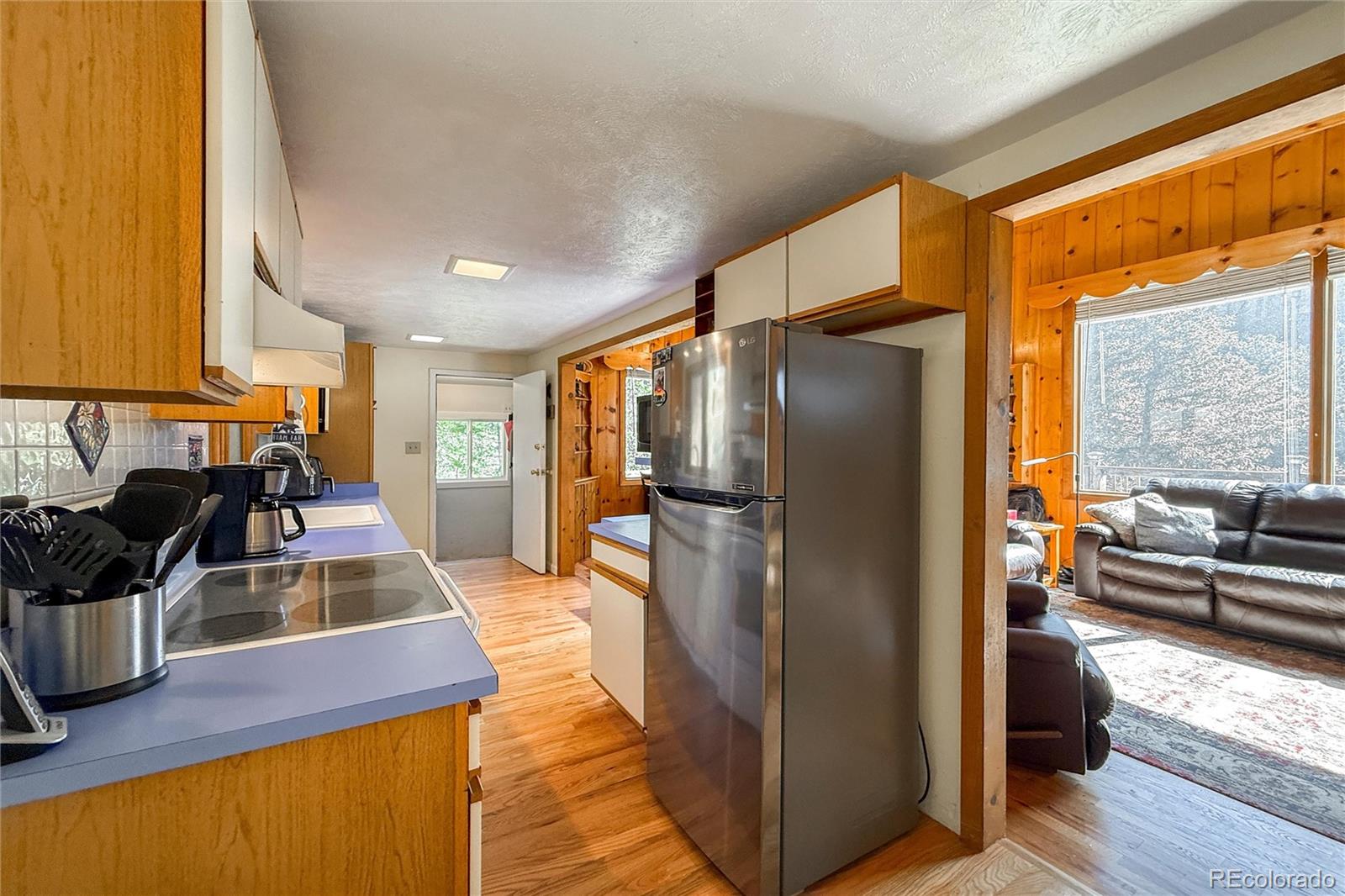 3148 Riverside Drive Lyons, CO 80540 - Photo 23 of 41 a kitchen with stainless steel appliances granite countertop a refrigerator a stove and a sink with wooden floor