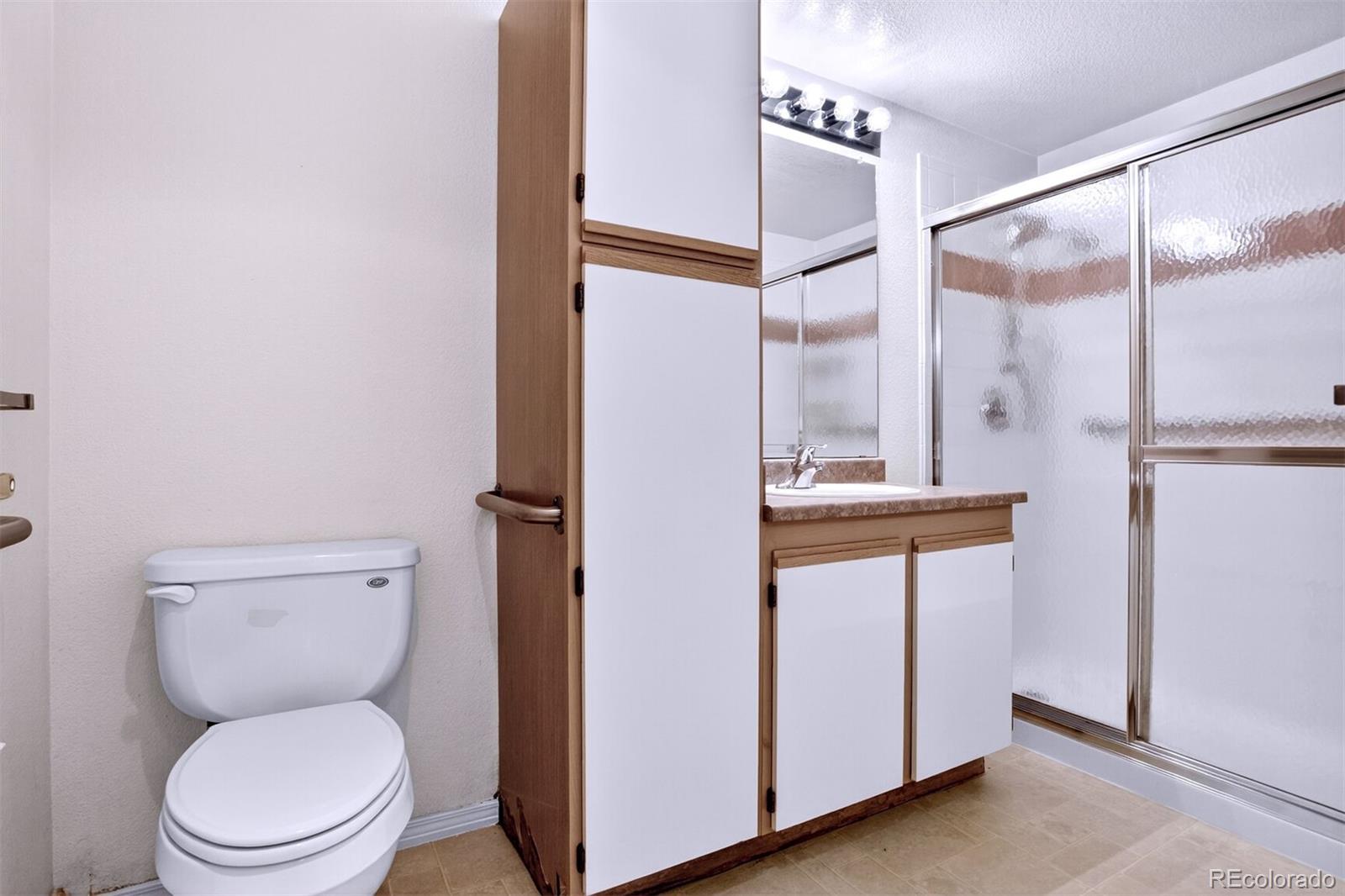 5320 Allison Street, Unit 106 Arvada, CO 80002 - Photo 11 of 15 a bathroom with a toilet a sink and a mirror