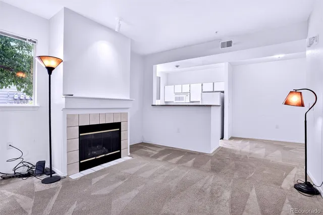 a view of a livingroom with a fireplace and window