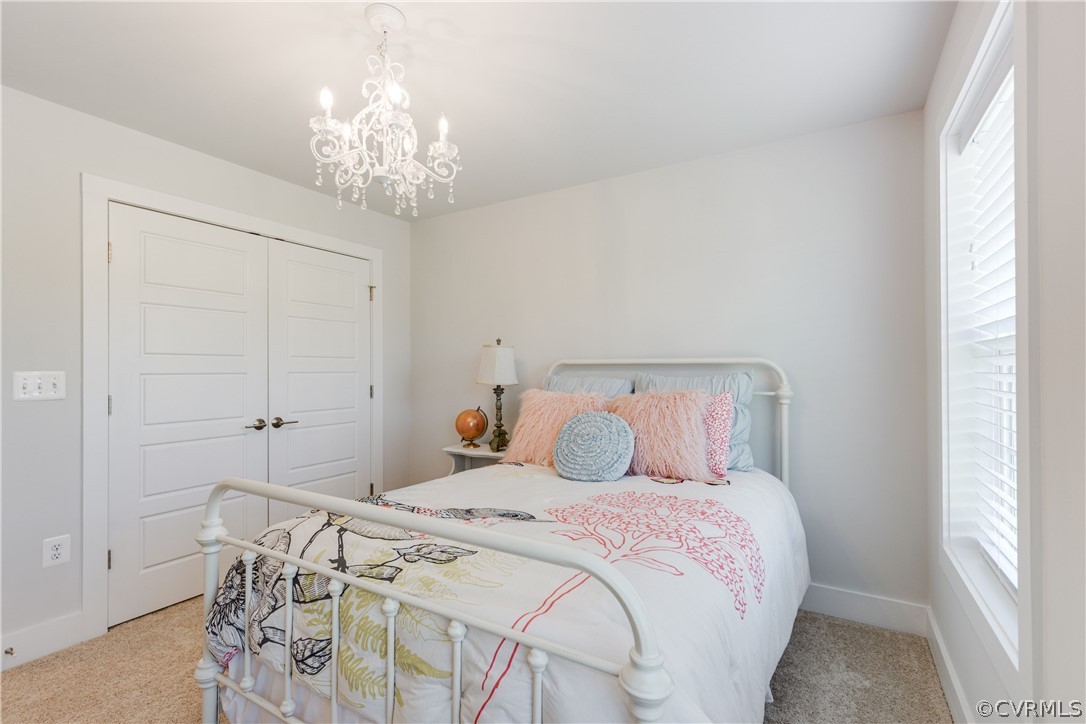 4332 Saunders Station Loop, Unit B Henrico, VA 23233 - Photo 33 of 42 a bedroom with a bed and a chandelier