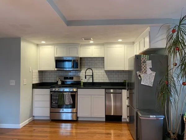 a kitchen with stainless steel appliances granite countertop a stove a sink and a microwave