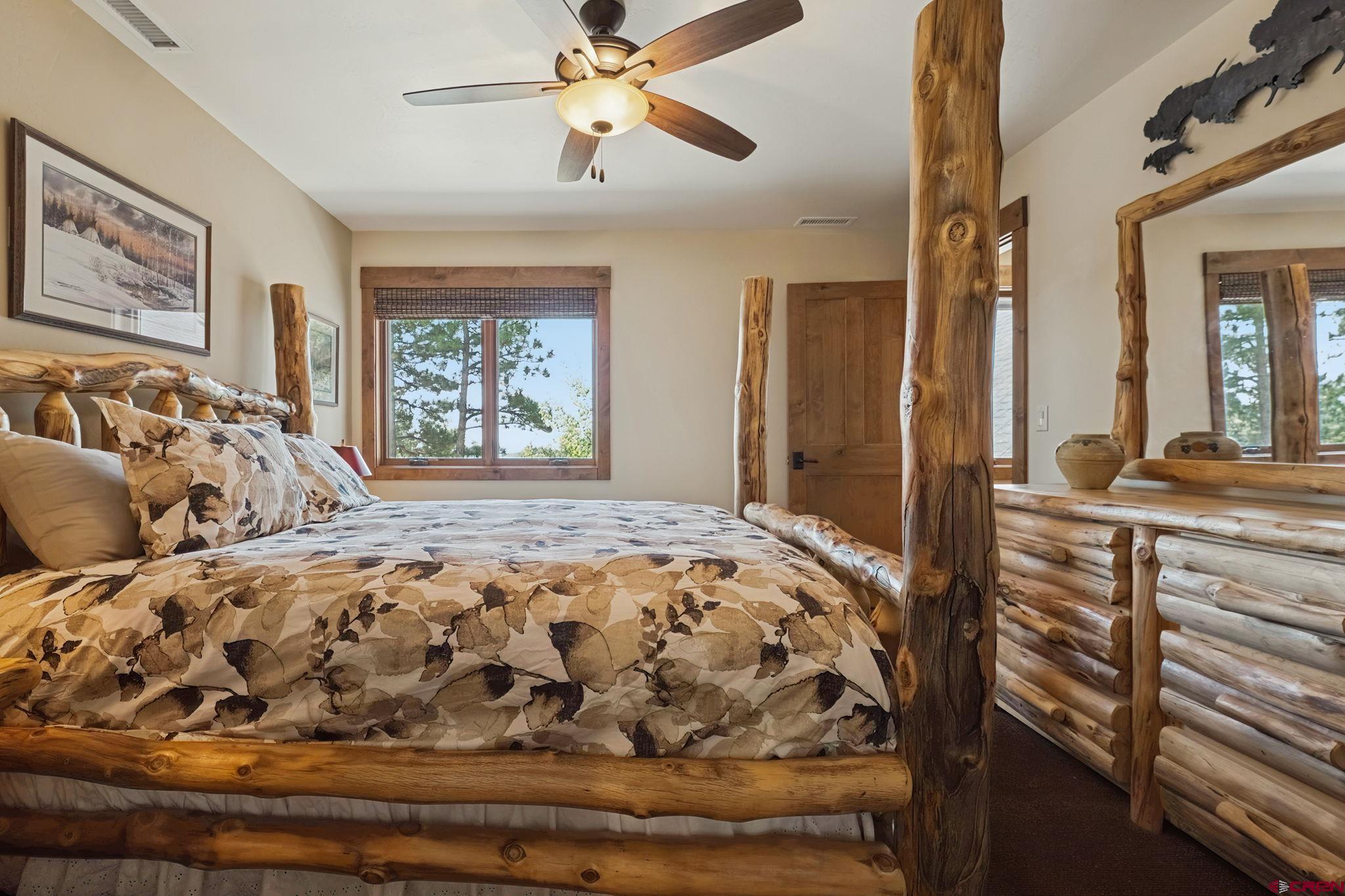 449 Monarch Crest Trail Durango, CO 81301 - Photo 34 of 45 a bedroom with a large bed and a chandelier