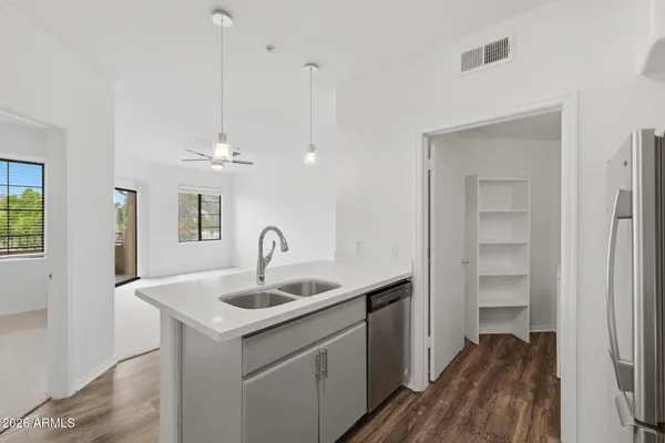 a kitchen with a sink chandelier and wooden floor