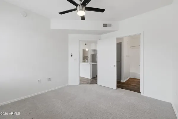 an empty room with closet and windows