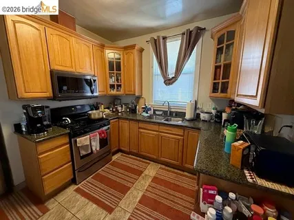 a kitchen with stainless steel appliances granite countertop a stove a sink and a microwave
