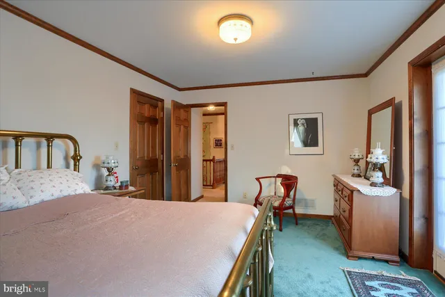 a bedroom with a bed next to a window with pc on the wall