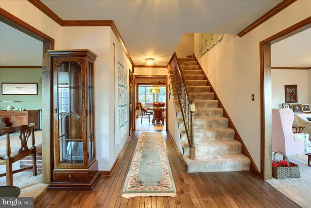 a view of a hallway with wooden floor and staircase