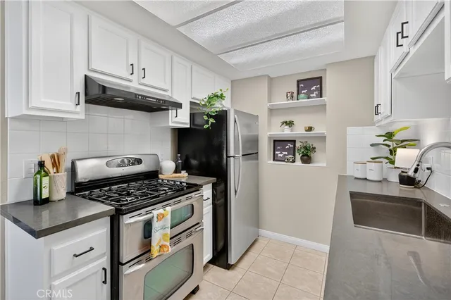 a kitchen with stainless steel appliances granite countertop a refrigerator and a stove