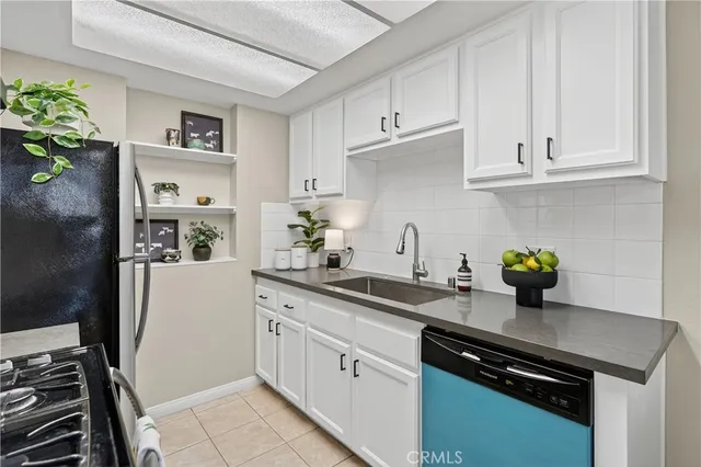 a kitchen with stainless steel appliances a white cabinets sink and wooden floor