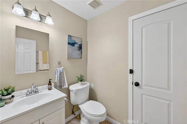 a bathroom with a sink vanity mirror and toilet