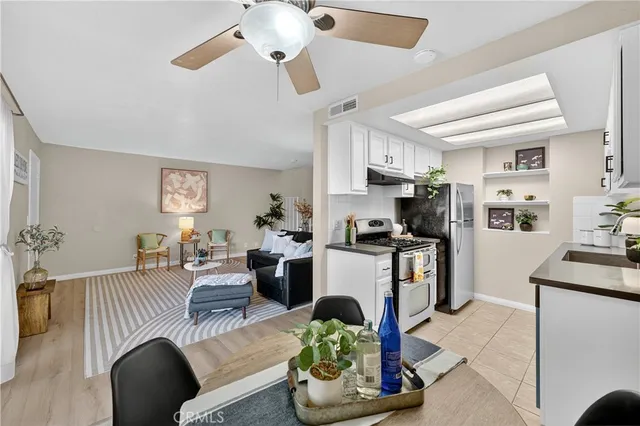 a living room with furniture kitchen view and a refrigerator