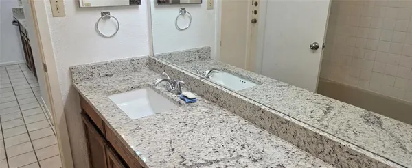 a view of bathroom with a granite countertop sink