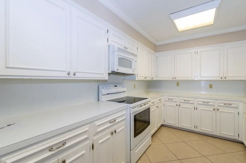 1118 Lincoln Street Alice, TX 78332 - Photo 8 of 32 a kitchen with white cabinets and white appliances