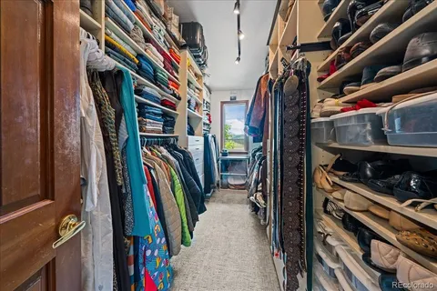 a view of walk in closet with clothes and shoes