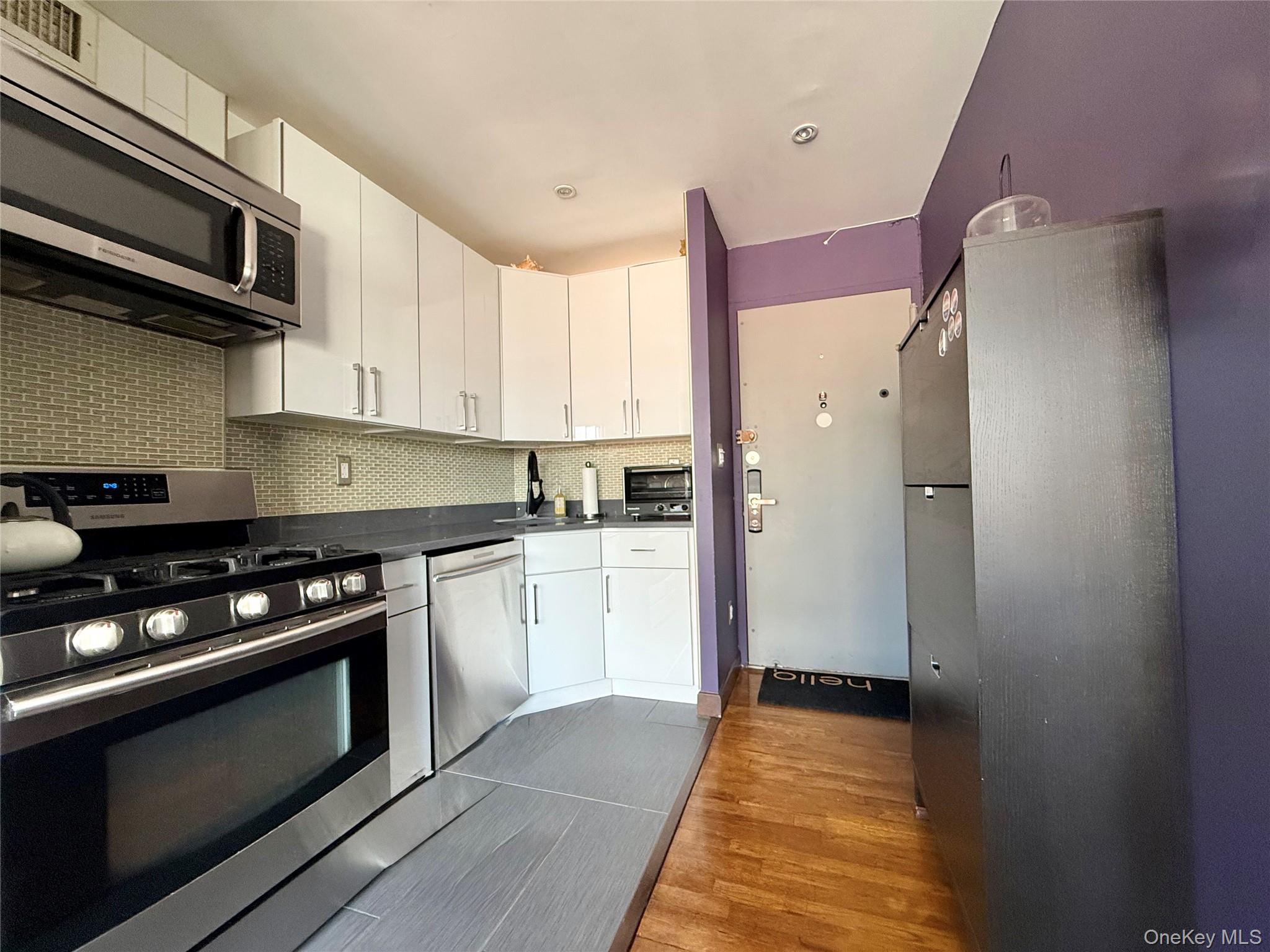 87-14 57th Road, Unit 5A Queens, NY 11373 - Photo 10 of 34 a kitchen with stainless steel appliances granite countertop a stove and a refrigerator