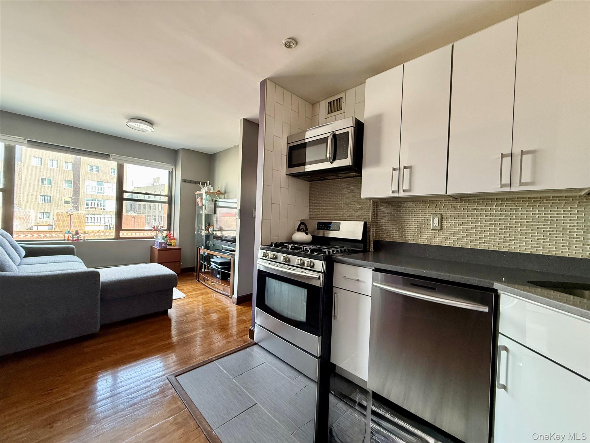 87-14 57th Road, Unit 5A Queens, NY 11373 - Photo 33 of 34 a kitchen with stainless steel appliances granite countertop a stove and a refrigerator