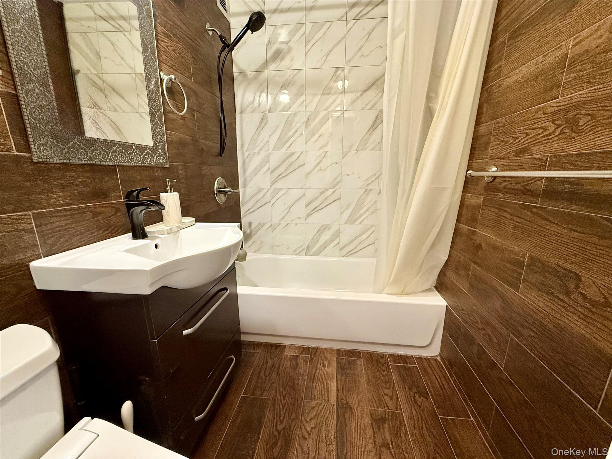 87-14 57th Road, Unit 5A Queens, NY 11373 - Photo 22 of 34 a bathroom with a sink a toilet a mirror and bathtub