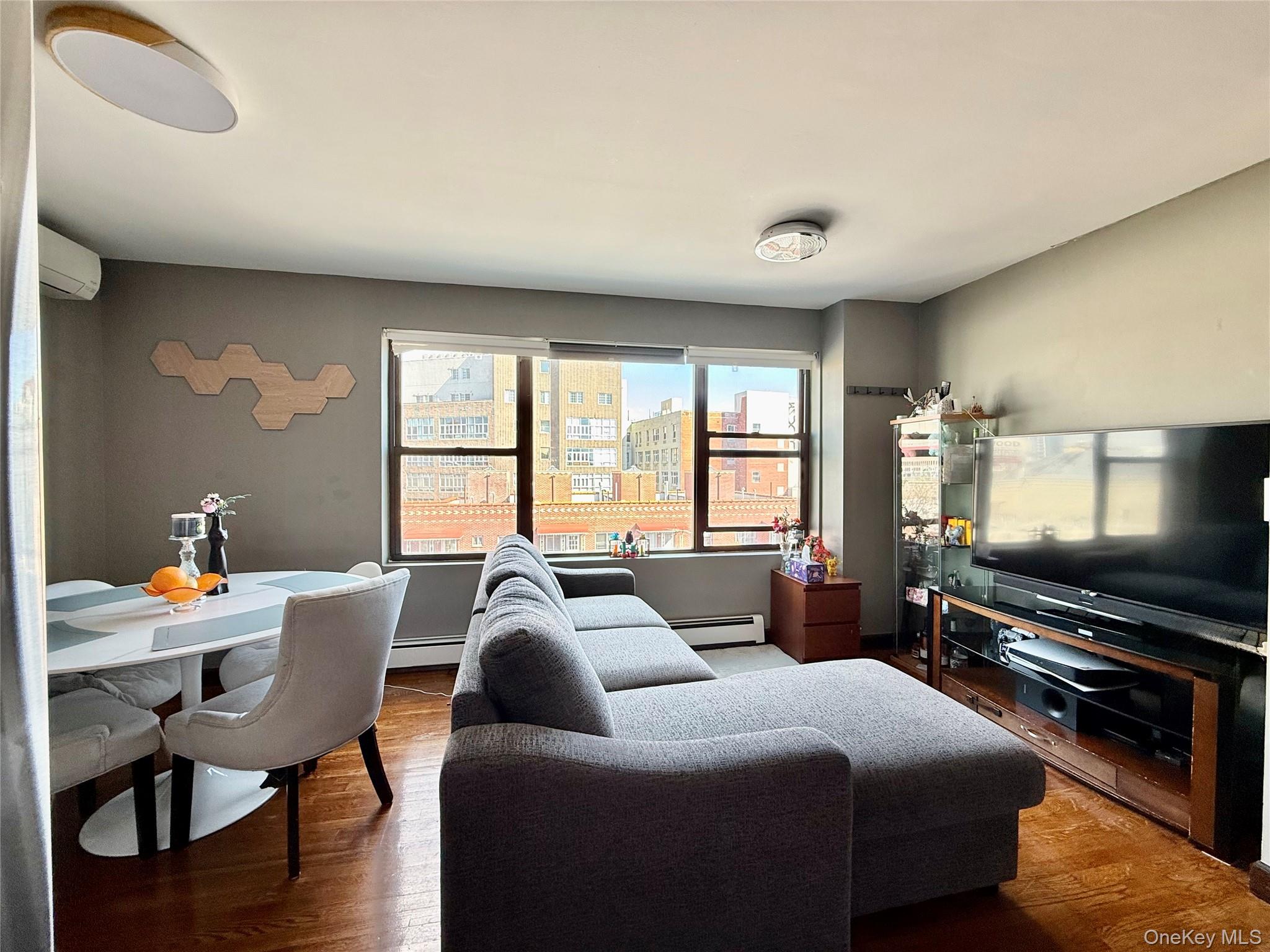 87-14 57th Road, Unit 5A Queens, NY 11373 - Photo 5 of 34 a living room with furniture and a flat screen tv