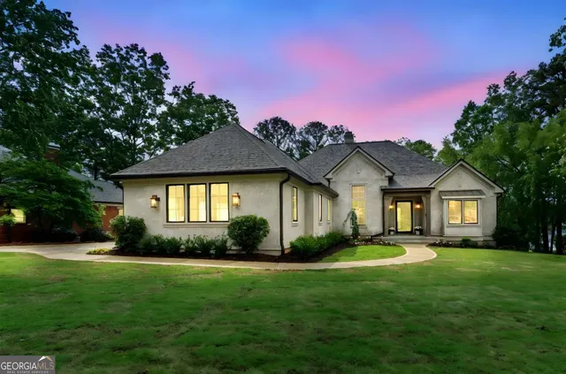 a front view of a house with a garden and plants