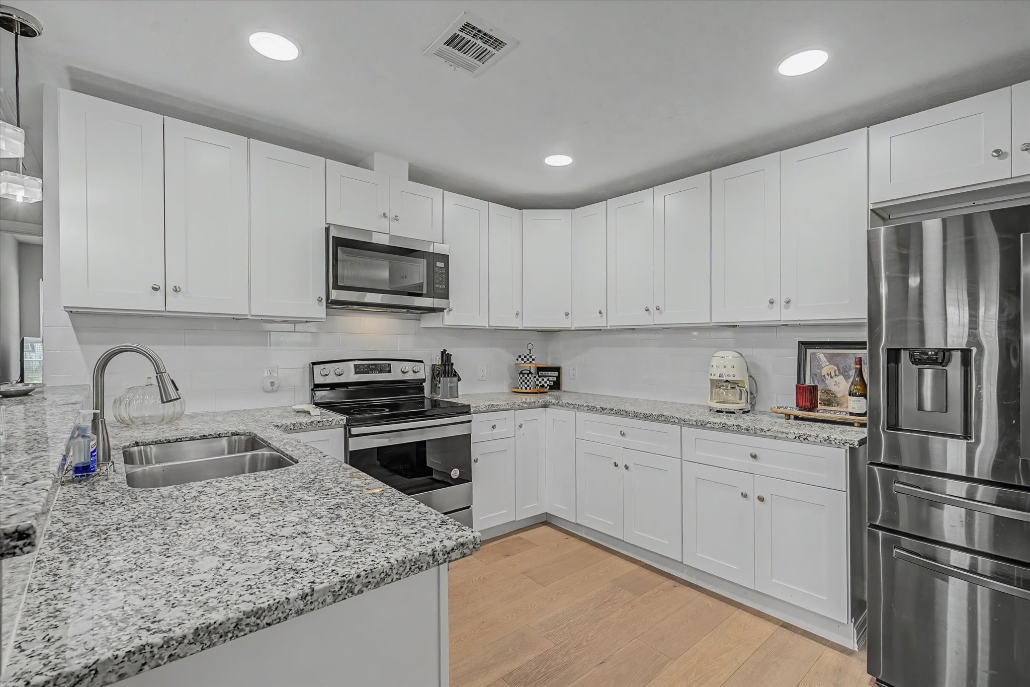 6834 New York Street Houston, TX 77021 - Photo 7 of 39 The modern kitchen boasts crisp white cabinetry, durable granite countertops.