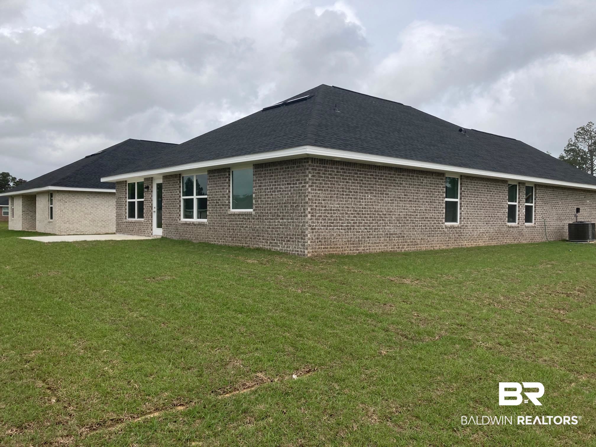 705 Mayflower Drive Foley, AL 36535 - Photo 18 of 19 Back of property with central air condition unit, a lawn, a patio, and brick siding