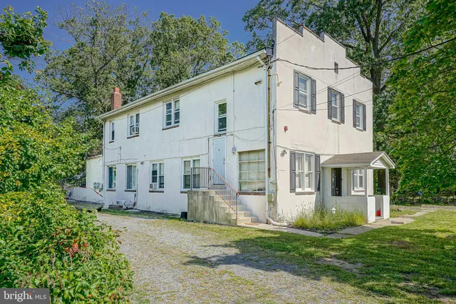 a view of a white house with a yard