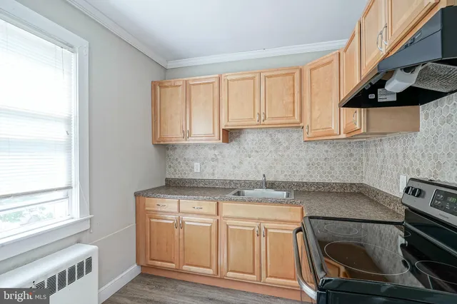 a kitchen with a sink stove and cabinets