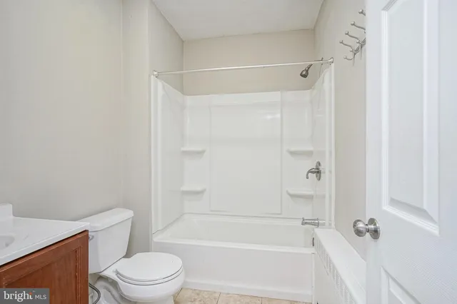 a bathroom with a bathtub shower sink vanity and toilet