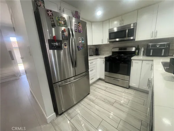 a kitchen with stainless steel appliances a refrigerator a stove a microwave and cabinets