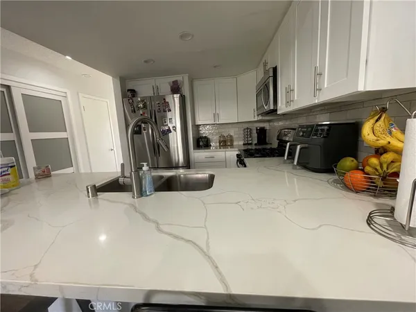 a kitchen with stainless steel appliances a sink a stove and cabinets