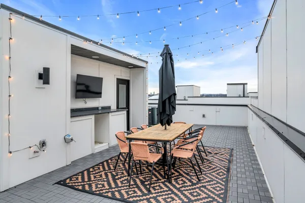 a kitchen with a dining table chairs and white appliances