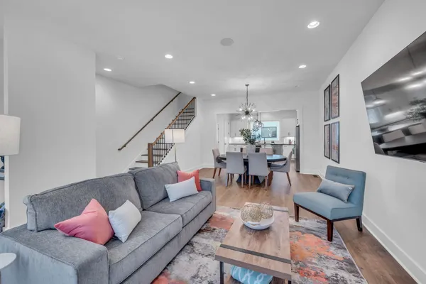 a living room with furniture kitchen view and a flat screen tv