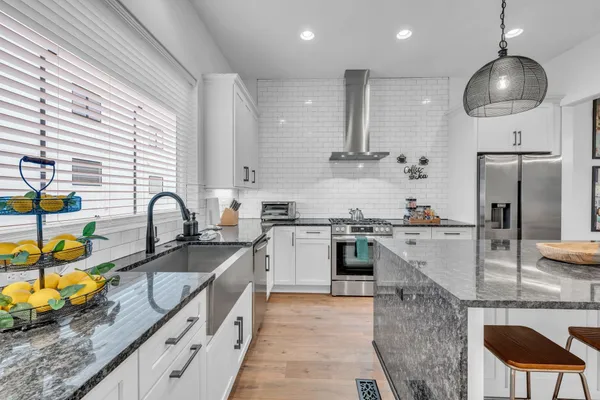a kitchen with stainless steel appliances granite countertop a sink and a stove