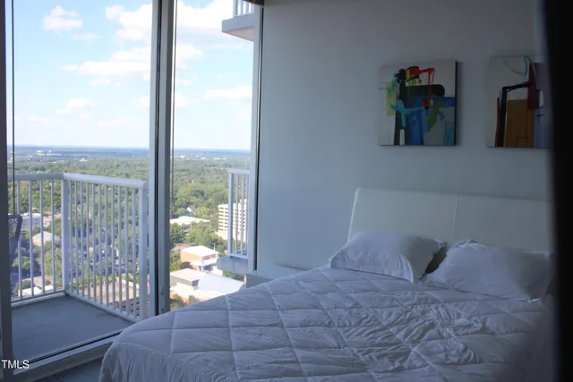 a bedroom with a large bed and a balcony next to a window