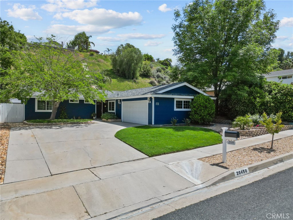 26450 Ridge Vale Drive Newhall, CA 91321 - Photo 2 of 40 a front view of a house with a yard and garage