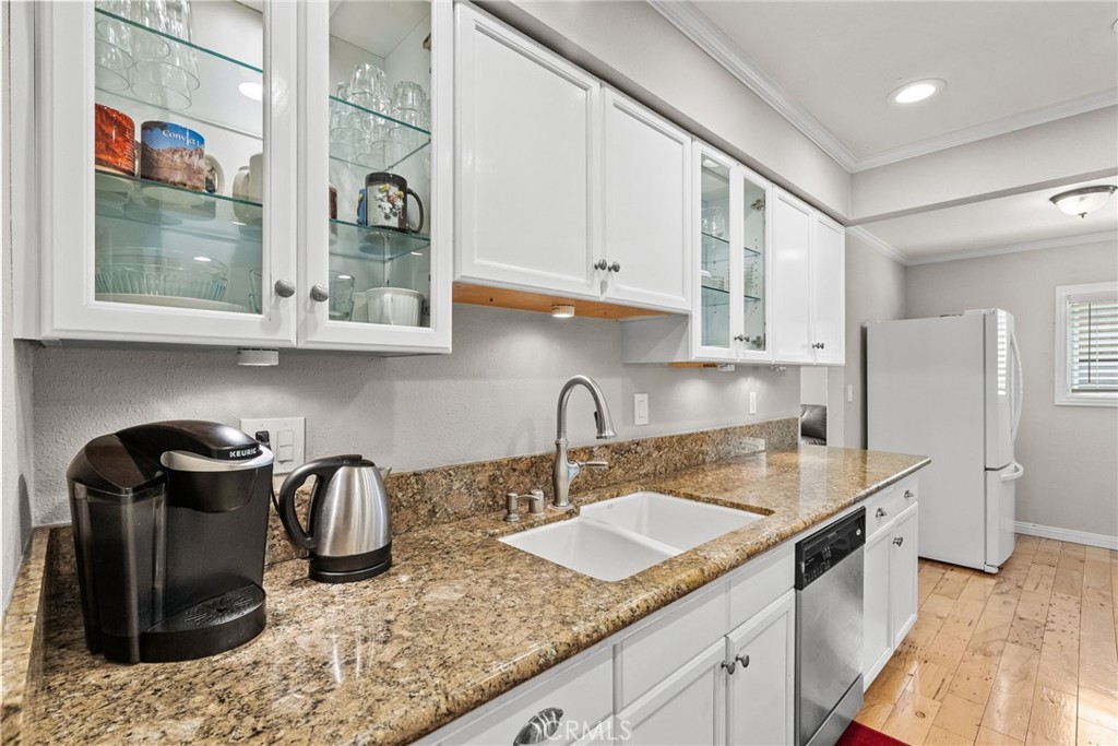26450 Ridge Vale Drive Newhall, CA 91321 - Photo 7 of 40 a kitchen with stainless steel appliances granite countertop a sink a stove and a wooden cabinets