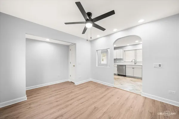 a view of a kitchen with wooden floor and a ceiling fan