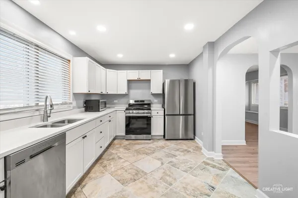 a large kitchen with stainless steel appliances granite countertop a refrigerator sink and cabinets