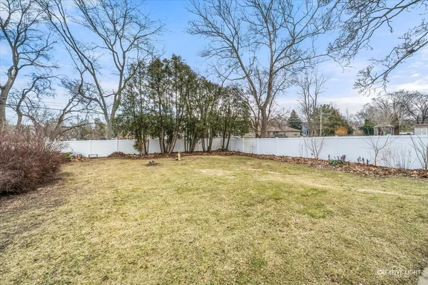 a view of yard with tree and wooden fence