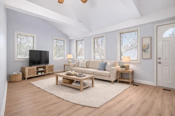 a living room with furniture a flat screen tv and a window