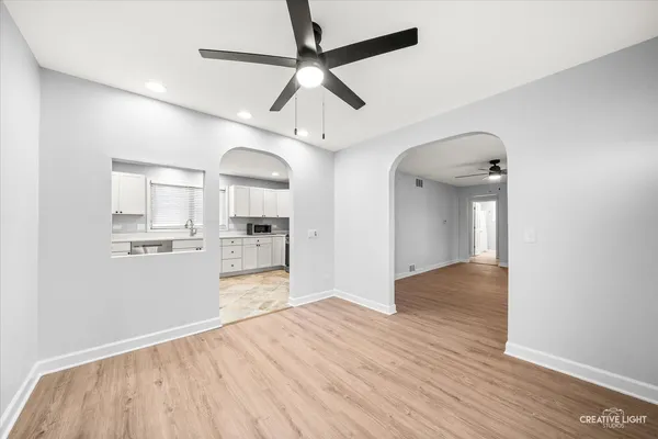 a view of a kitchen with wooden floor and a ceiling fan