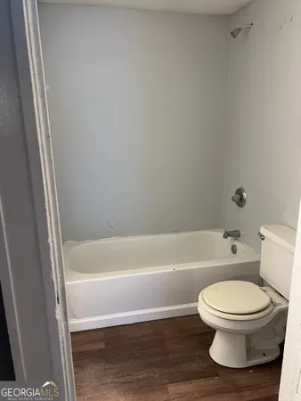 a bathroom with a toilet and a bath tub