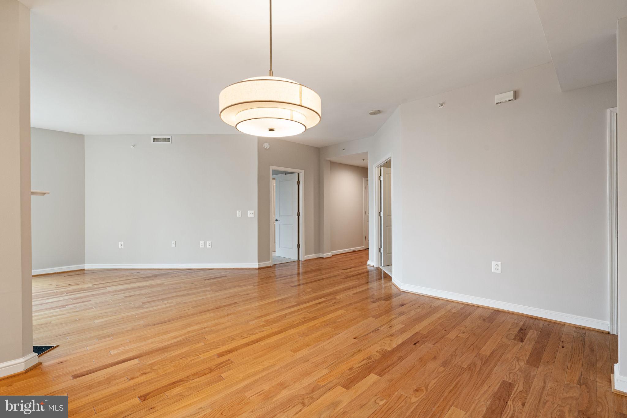 11990 Market Street, Unit 1311 Reston, VA 20190 - Photo 24 of 59 a view of an empty room with wooden floor and a window