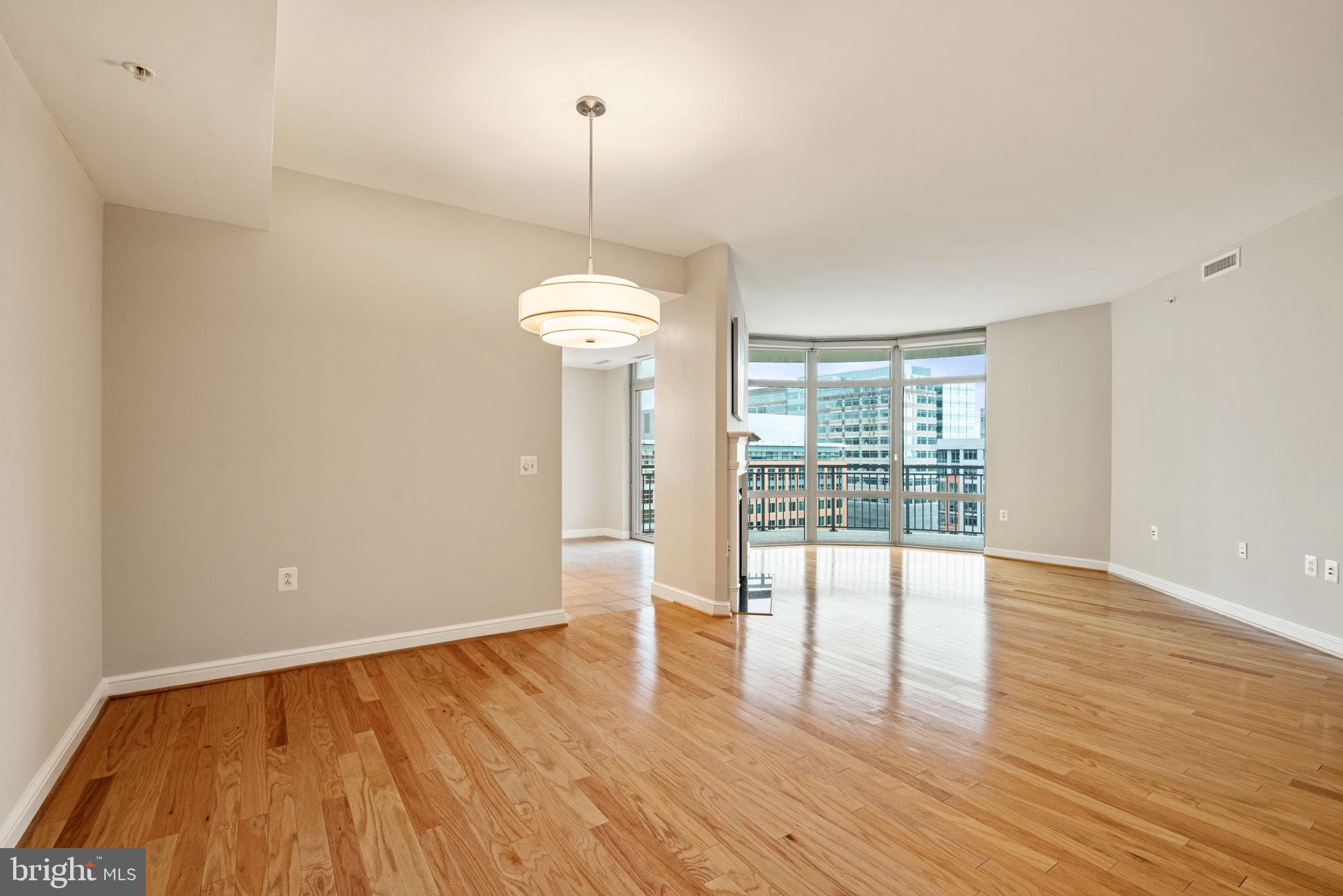 11990 Market Street, Unit 1311 Reston, VA 20190 - Photo 26 of 59 a view of an empty room with wooden floor and a window