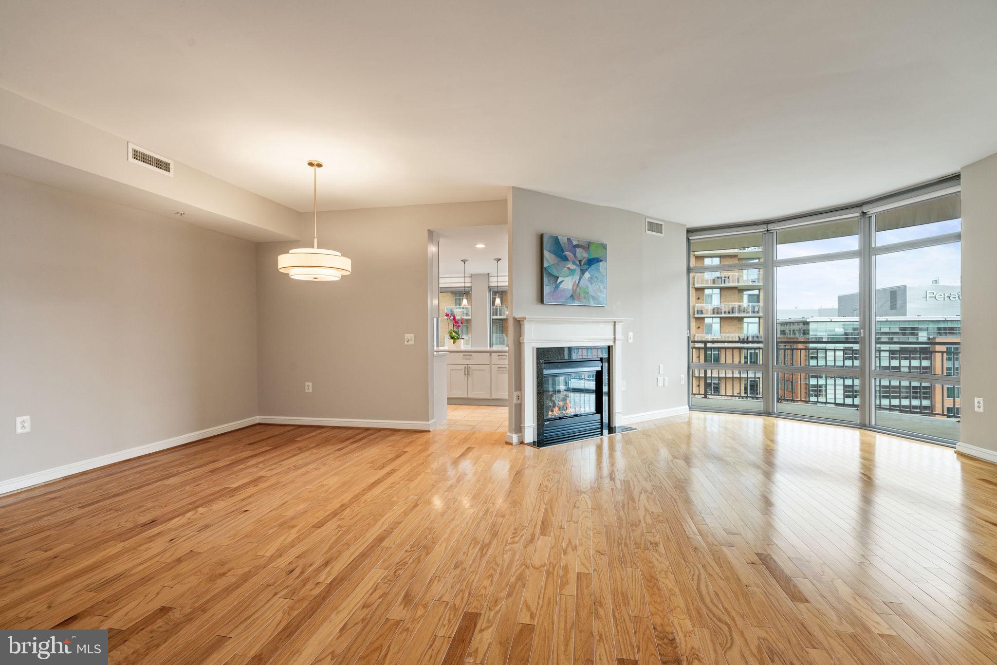 11990 Market Street, Unit 1311 Reston, VA 20190 - Photo 27 of 59 an empty room with fireplace wooden floor and windows
