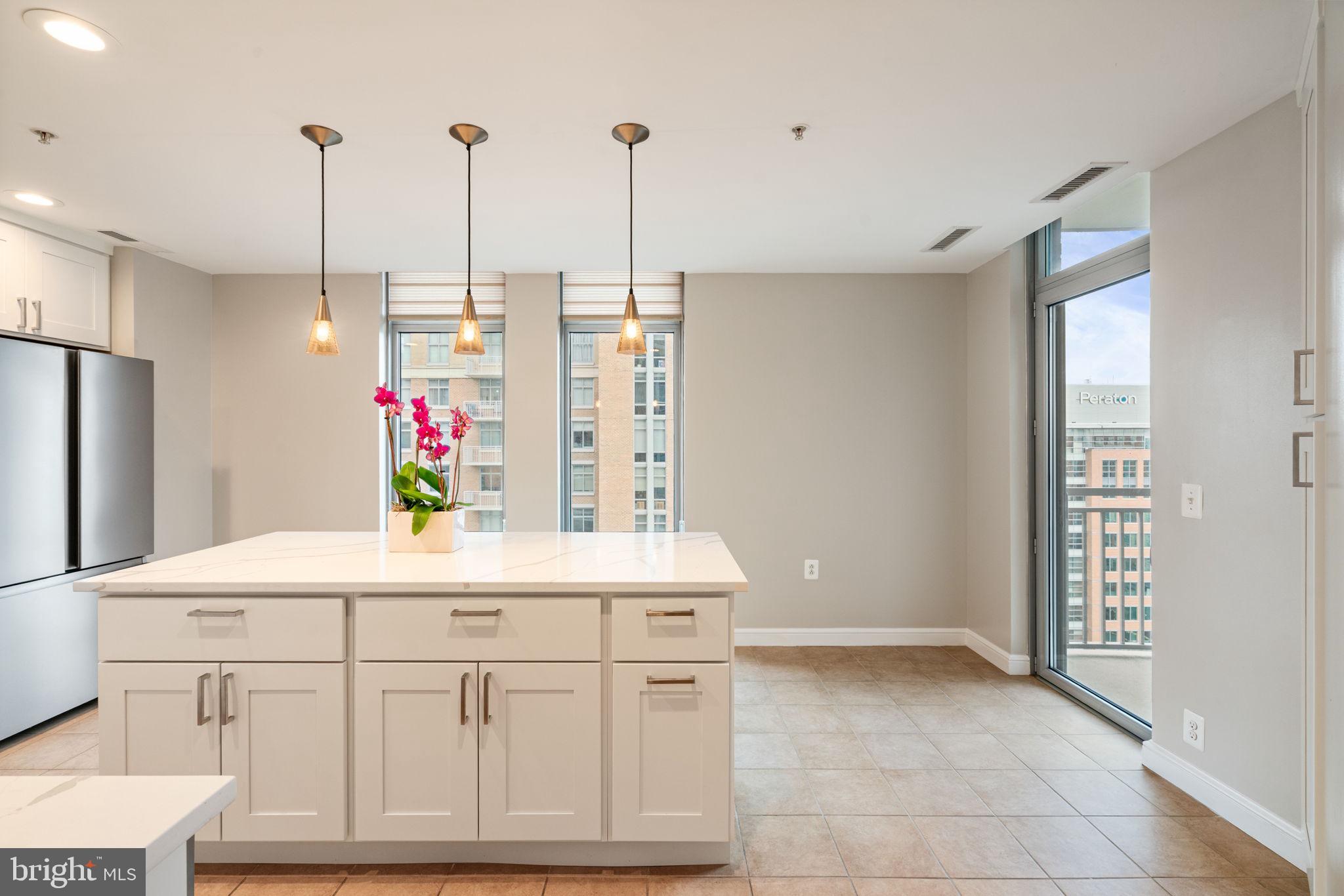 11990 Market Street, Unit 1311 Reston, VA 20190 - Photo 28 of 59 a kitchen with stainless steel appliances kitchen island granite countertop a refrigerator and microwave