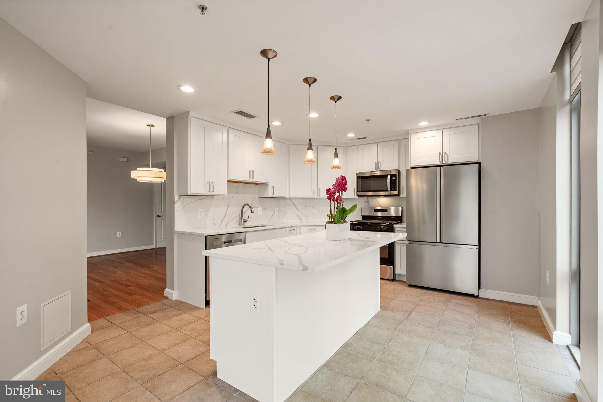 11990 Market Street, Unit 1311 Reston, VA 20190 - Photo 30 of 59 a kitchen with a refrigerator a sink and cabinets