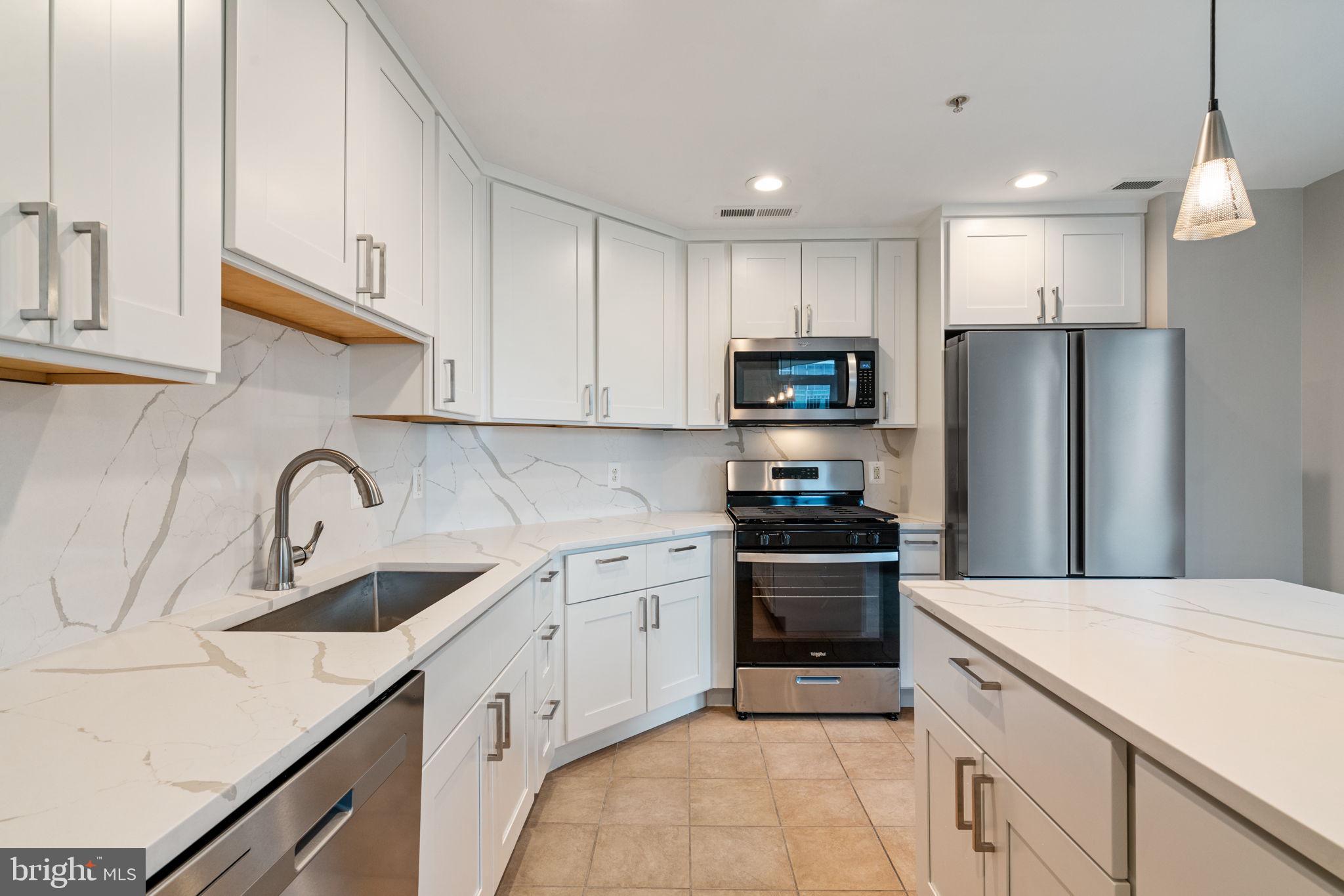 11990 Market Street, Unit 1311 Reston, VA 20190 - Photo 31 of 59 a kitchen with stainless steel appliances granite countertop a sink dishwasher a refrigerator and a stove