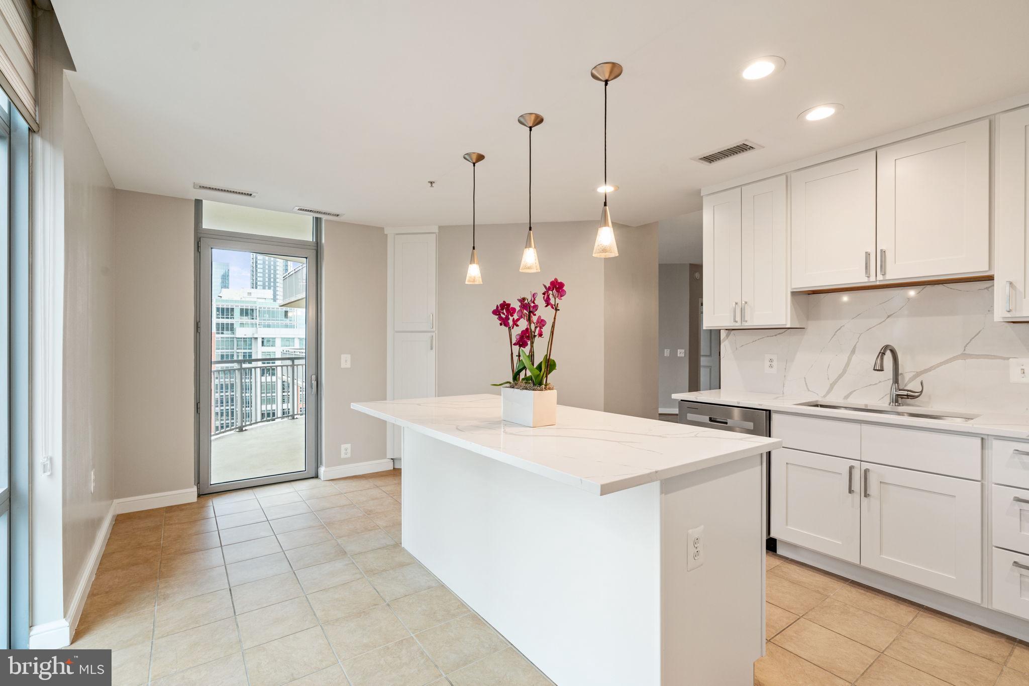 11990 Market Street, Unit 1311 Reston, VA 20190 - Photo 33 of 59 a view of a kitchen with kitchen island a sink stainless steel appliances and cabinets