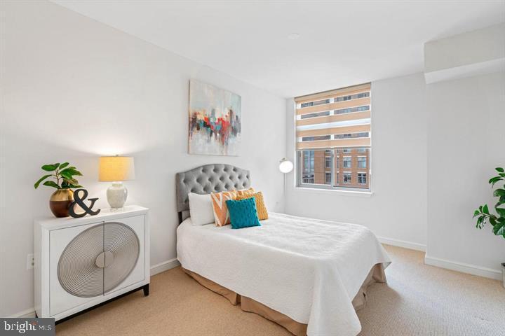 11990 Market Street, Unit 1311 Reston, VA 20190 - Photo 48 of 59 a bedroom with a bed a dresser and potted plants